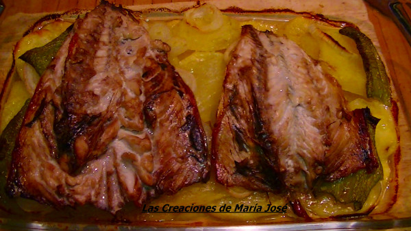 CABALLA AL HORNO SOBRE CAMA DE PATATAS Y CEBOLLA